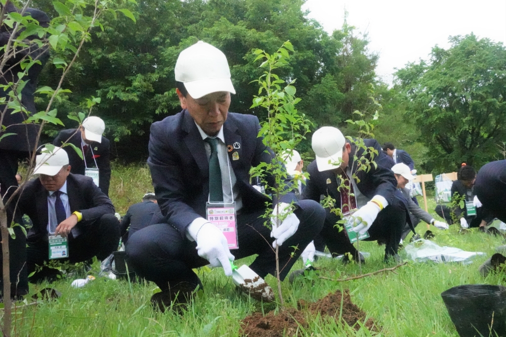 ヤマザクラを植樹する社長の加藤